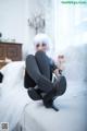 A woman sitting on top of a white couch.