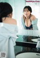 A woman in a blue bikini looking at herself in the mirror.