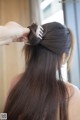 A woman with long brown hair is getting her hair styled.