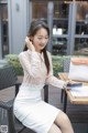 A woman sitting at a table with a cell phone in her hand.