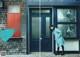 A woman standing in front of a blue door.