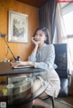 A woman sitting at a desk talking on a cell phone.