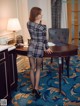 A woman in a black and white dress standing at a desk.