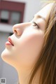 A woman with long brown hair is looking up at the sky.