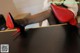 A woman in black stockings and red high heels sitting on a table.