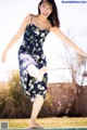 A woman in a blue dress jumping into a swimming pool.