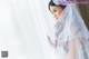 A woman in a wedding dress looking out a window.