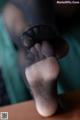 A close up of a person's feet in black stockings.