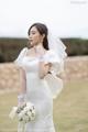 A woman in a wedding dress holding a bouquet of flowers.