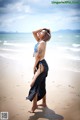 A woman in a bikini standing on a beach.