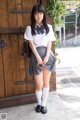 A young woman in a school uniform posing for a picture.