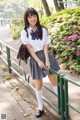 A young woman in a school uniform posing for a picture.