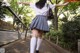 A woman in a school uniform is walking down the street.