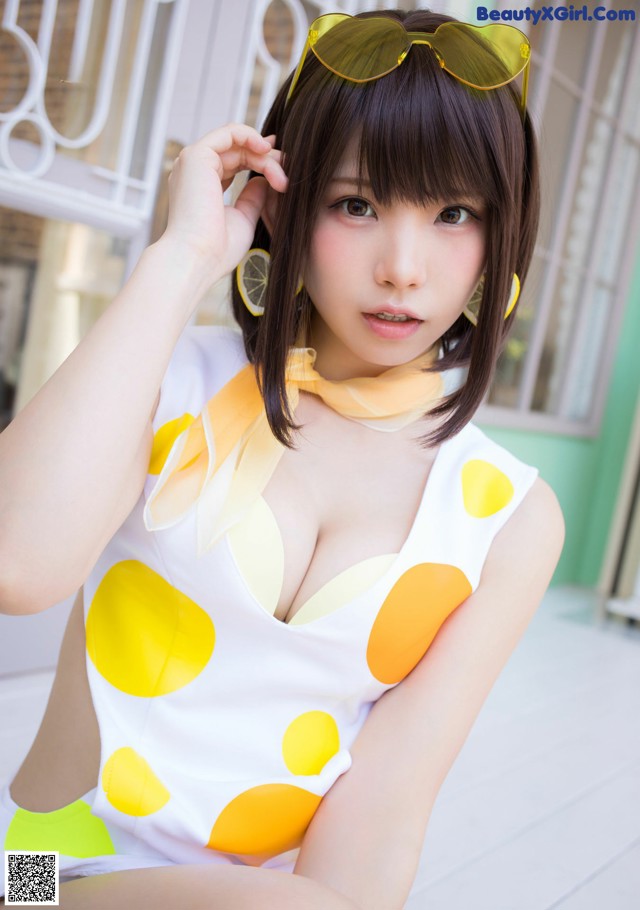 A woman in a yellow and white polka dot dress and sunglasses.