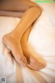 A woman's legs are shown on a bed.