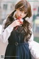 A young woman in a school uniform holding a red ribbon.