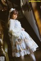 A woman in a blue and white dress standing on a staircase.