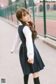 A woman in a school uniform is walking down the street.