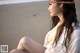 A woman sitting on a beach next to the ocean.