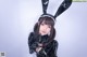 A woman in a black bunny costume posing for a picture.