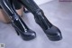 A close up of a pair of black shoes on a table.