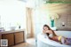 A woman laying in a bathtub in a bathroom.