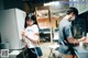 A man and a woman standing in a kitchen next to a refrigerator.